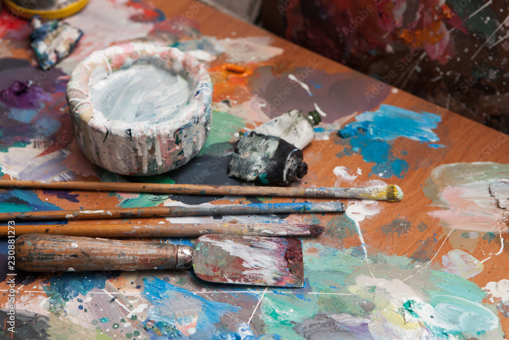 Oil paints and paint brushes on a palette, in the studio of artist. Oil paints and paint brushes on a palette, in the studio of artist.