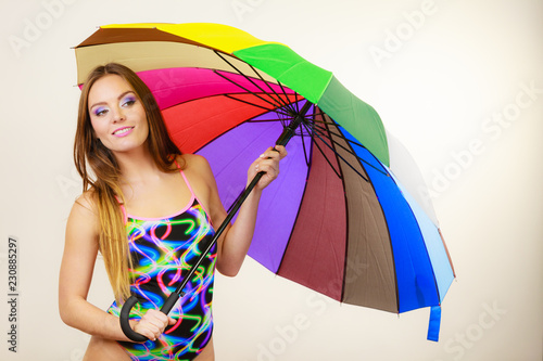 Happy woman posing in swimsuit and colorful umbrella photo