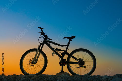 Fototapeta Naklejka Na Ścianę i Meble -  Silhouette of mountain bicycle against sunset sky