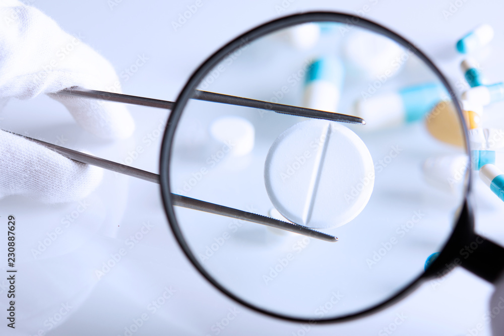 suspicious medications under a magnifying glass suspicious medications under a magnifying glass