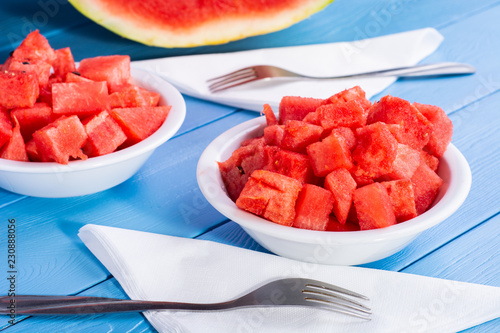 fresh watermelon cut into cubes on plates.