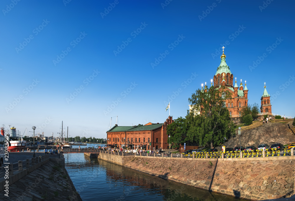 Embankment of Helsinki at summer evening, Finland. Town Quay and Uspenski Orthodox Cathedral Church in Katajanokka district of the Old Town, popular and famous tourist destination in Helsinki Embankment of Helsinki at summer evening, Finland. Town Quay and Uspenski Orthodox Cathedral Church in Katajanokka district of the Old Town, popular and famous tourist destination in Helsinki