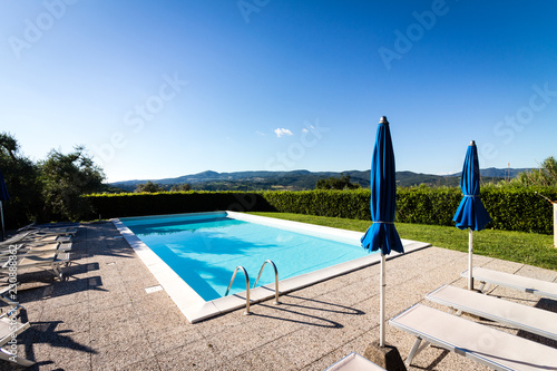 Leerer Swimmingpool vor blauem Himmel in der Toscana photo