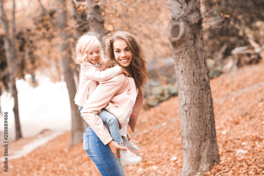 Smiling baby girl on mother hands in park. Looking at camera. Motherhood. 20s. Smiling baby girl on mother hands in park. Looking at camera. Motherhood. 20s.
