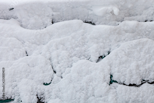 Surface of car is covered with snow