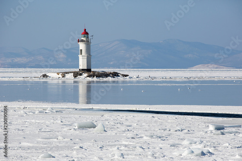 Aerial winter view of the Tokarevskiy lighthouse - one of the oldest lighthouses in the Far East, still an important navigational structure and popular attractions of Vladivostok city, Russia.	 photo