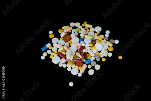 The pills are scattered on a black background. Tablets are scattered. Placebo