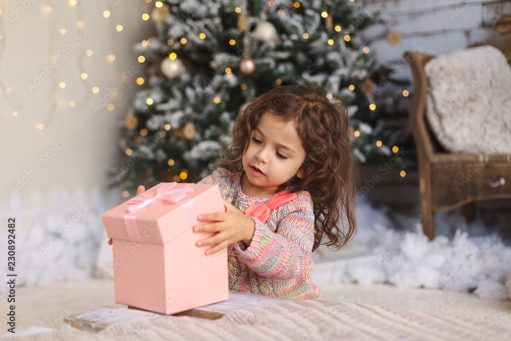 Little girl opening Christmas gift Little girl opening Christmas gift