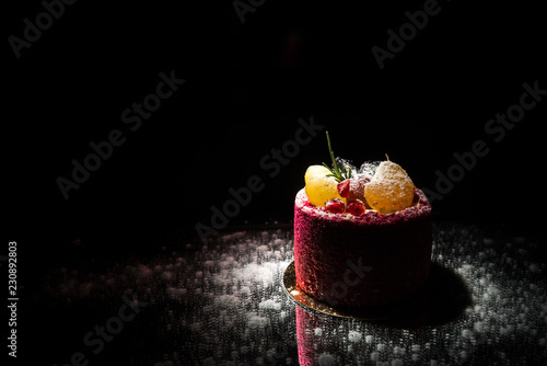 Tasty red cake with fruit on a black background