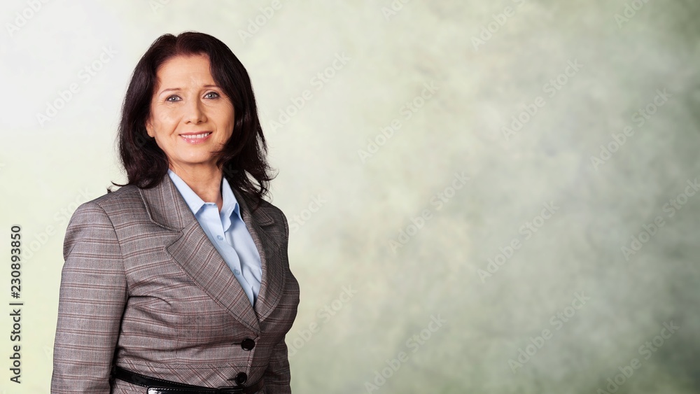 Mature businesswoman wearing formal suit on background Mature businesswoman wearing formal suit on background