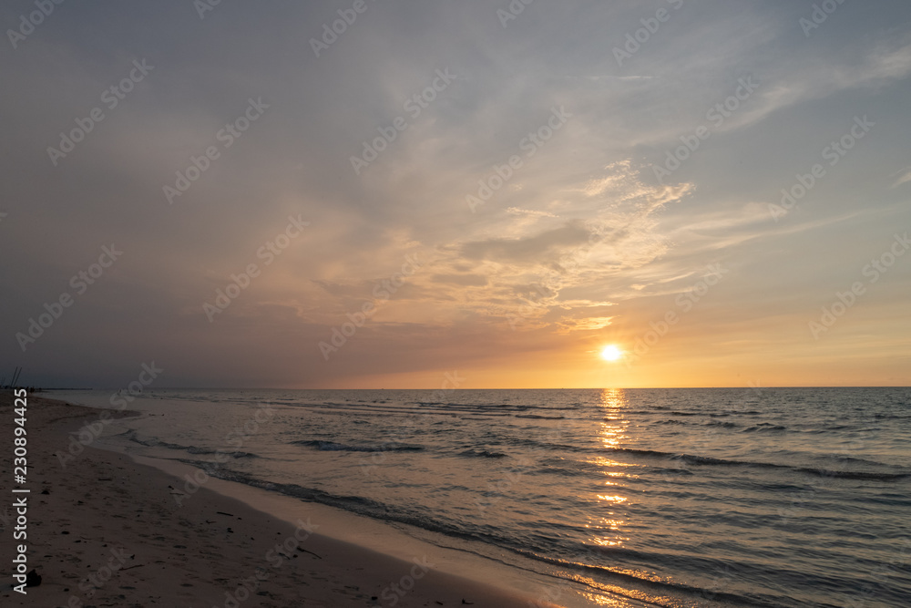 sandy beach by the ocean at sunset