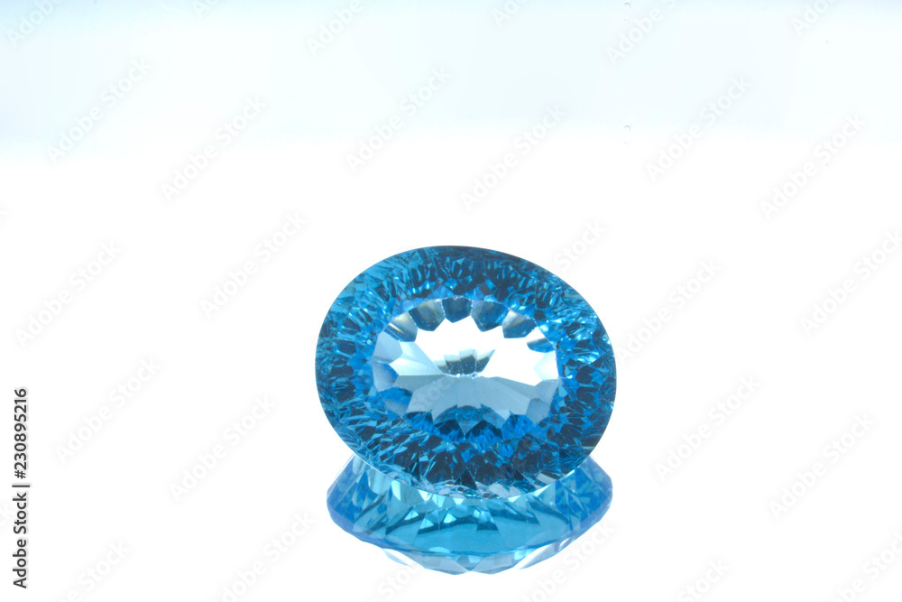 Circular gem of blue topaz on a glass Circular gem of blue topaz on a glass