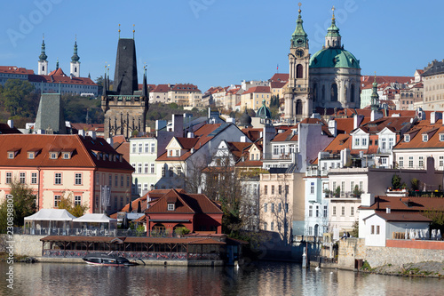 Colorful autumn Prague St. Nicholas' Cathedral with the Lesser Town above River Vltava in the sunny Day, Czech Republic