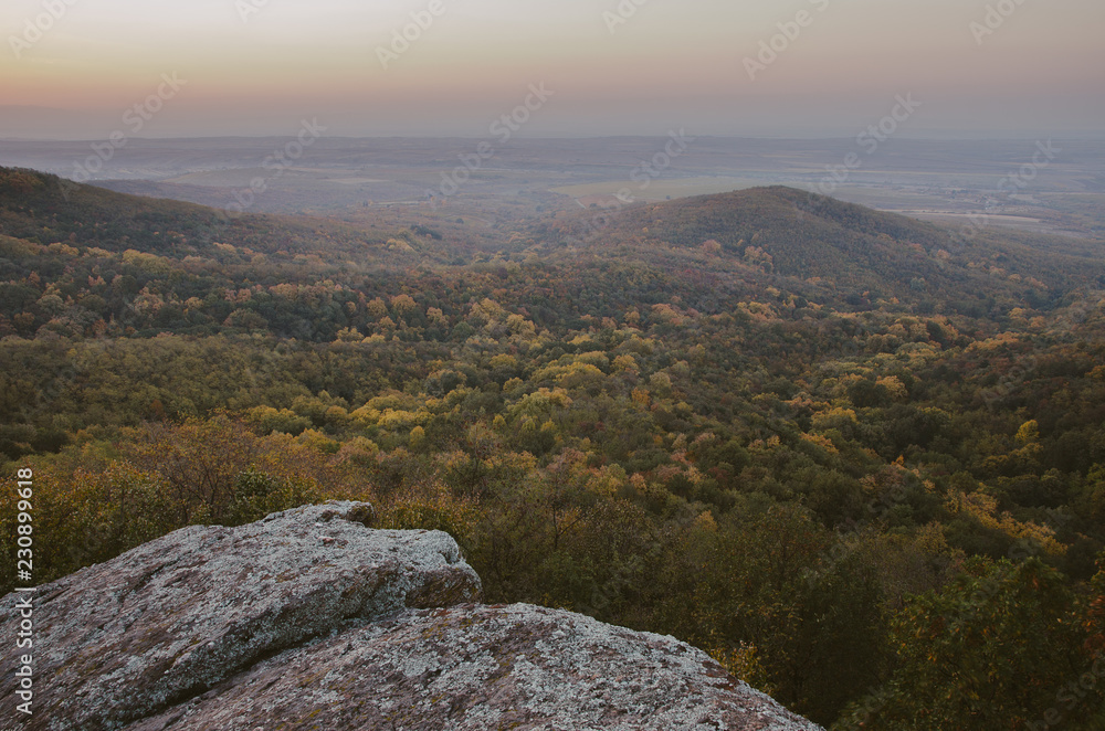 View on a hill in a valley at autumn sunset