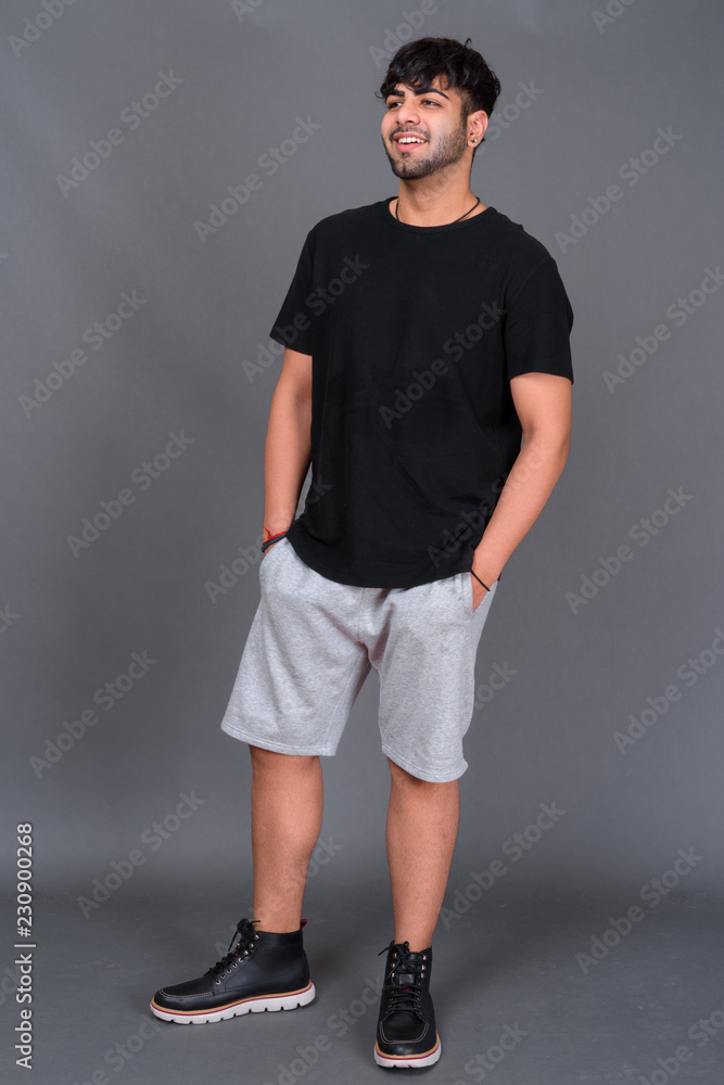 Young handsome Indian man against gray background Young handsome Indian man against gray background