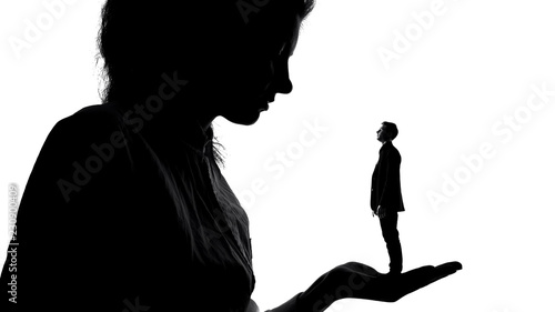 Shadow of female holding tiny man in love in hand, women power, domination