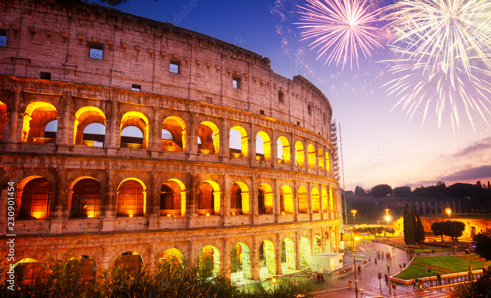 view of Colosseum illuminated at night with fireworks in Rome, Italy