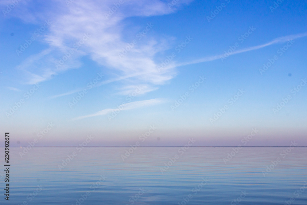 Obraz premium Summer seascape. Skyline in the ocean. The colors of nature. Clear sky. Water surface Reflection of the sky in the water.