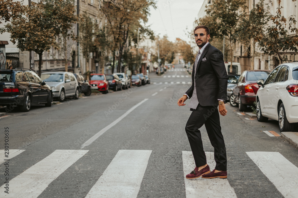 Elegant bearded businessman crossing the street Elegant bearded businessman crossing the street