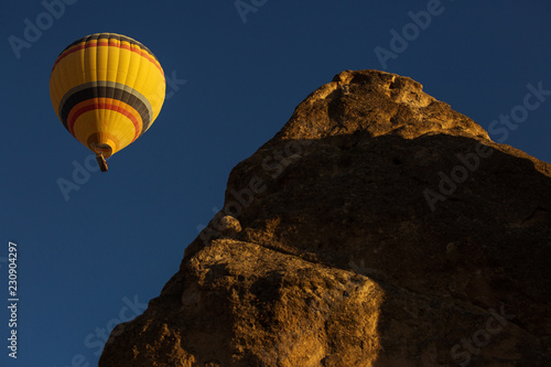 Colorful hot air balloon flying over a beatiful blue sky in background © danmir12