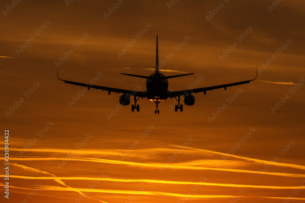 Air plane taking off at sunset near to the sun with beautiful red cloud in background