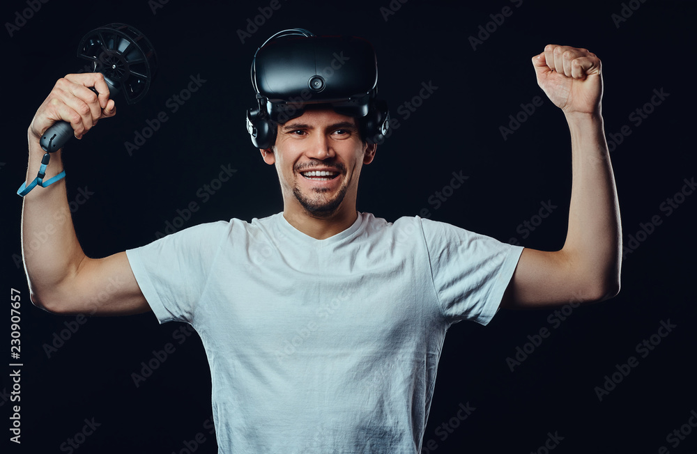Pro player rejoices in his victory in the competition, wearing virtual reality glasses and holds joysticks. Pro player rejoices in his victory in the competition, wearing virtual reality glasses and holds joysticks.