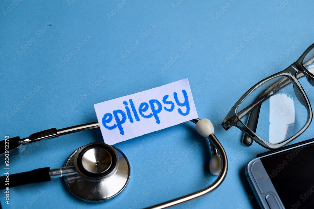 Conceptual image with Epilepsy inscription with the view of stethoscope, eyeglasses and smartphone on the blue background. Medical Conceptual. Conceptual image with Epilepsy inscription with the view of stethoscope, eyeglasses and smartphone on the blue background. Medical Conceptual.