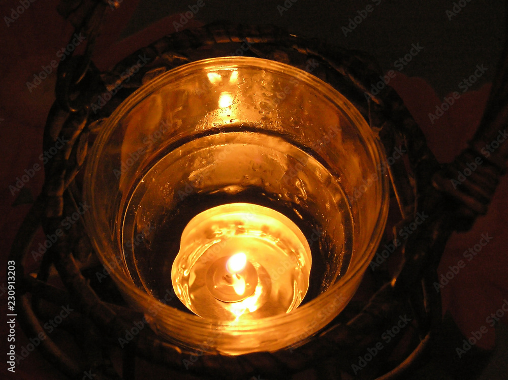 mysterious glow of a burning candle in a glass mysterious glow of a burning candle in a glass