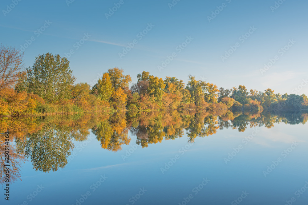 Beautiful autumn landscape. Reflection of trees in water.