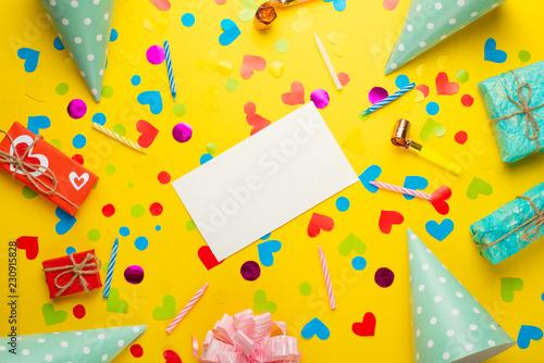 Festive frame or bright background, gift, confetti, carnival hat and streamer. Flat style. Birthday or holiday card with a copy.