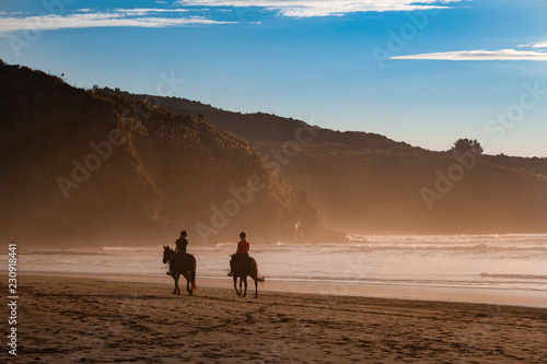 couple on the beach and horses