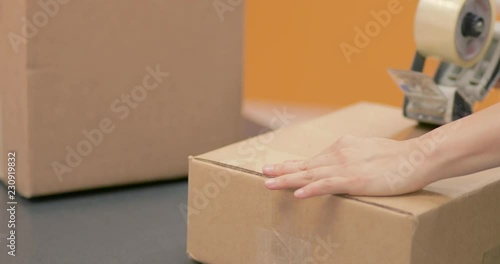 Taping and sealing a package box for shippment. Save money this Holiday using recycled boxes. Shot in 4k 30fps slow motion
