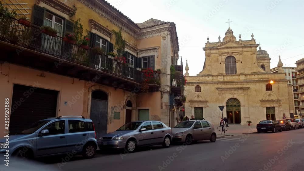 Modica catholic church (Saint Maria of Betlem) in Sicily - Italy at the right side of the scene in the other side of the street. Car passes from the left to the right. Modica catholic church (Saint Maria of Betlem) in Sicily - Italy at the right side of the scene in the other side of the street. Car passes from the left to the right.