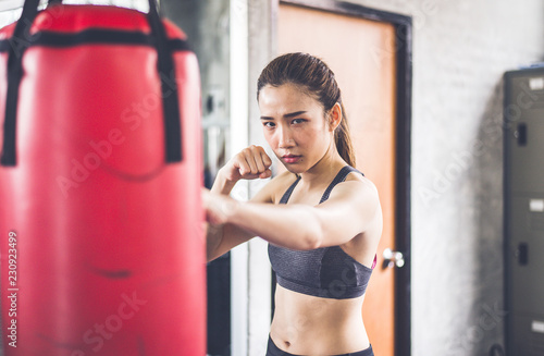 Woman boxer punching at a boxing gym,Female boxer training on punching bag