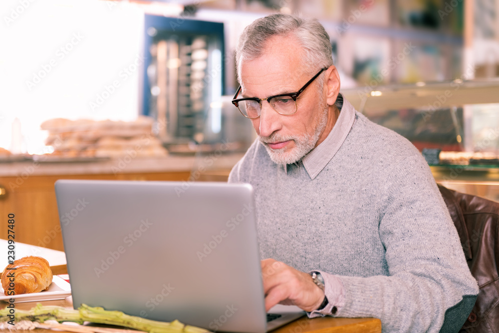 New poetry. Experienced mature grey-haired writer wearing glasses working on his new poetry New poetry. Experienced mature grey-haired writer wearing glasses working on his new poetry