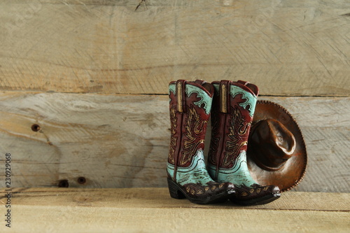 cowboy boots and hat isolated on a natural wood background with writing space photo