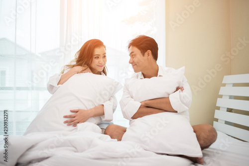 Happy young couple is having fun in bed