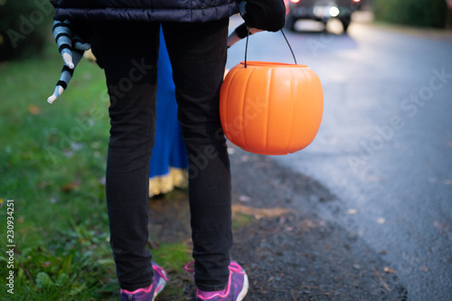 Children with Halloween pumpkin baskets during trick or treat session.