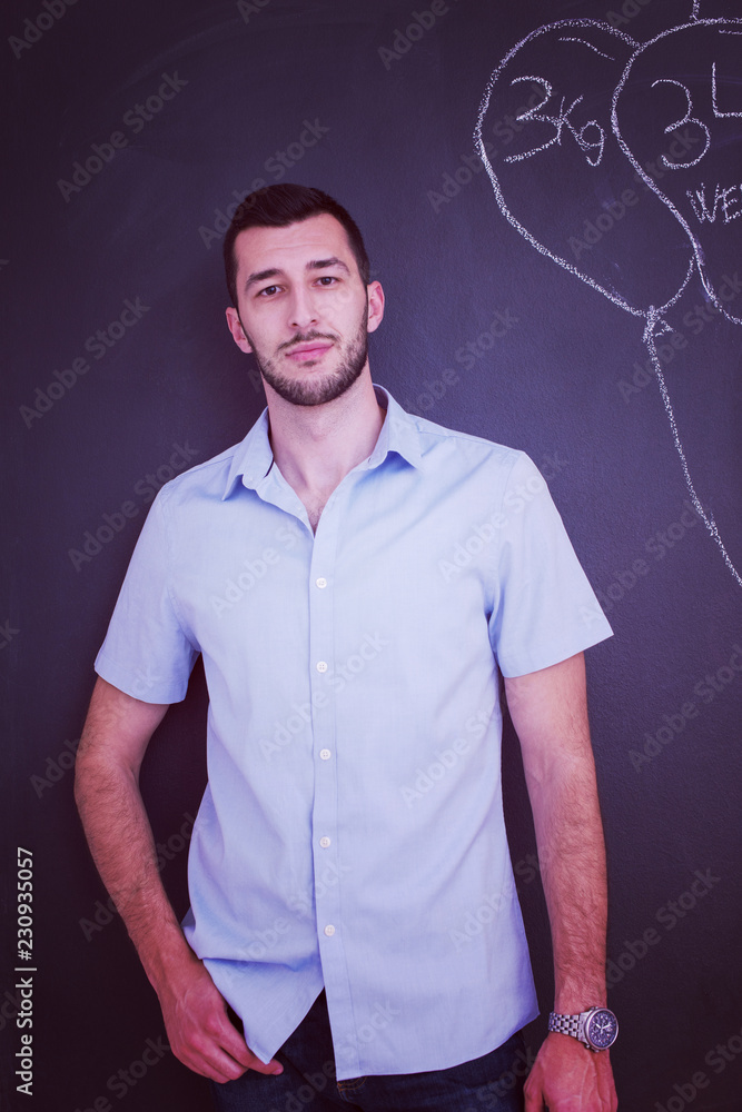 portrait of man in front of black chalkboard portrait of man in front of black chalkboard