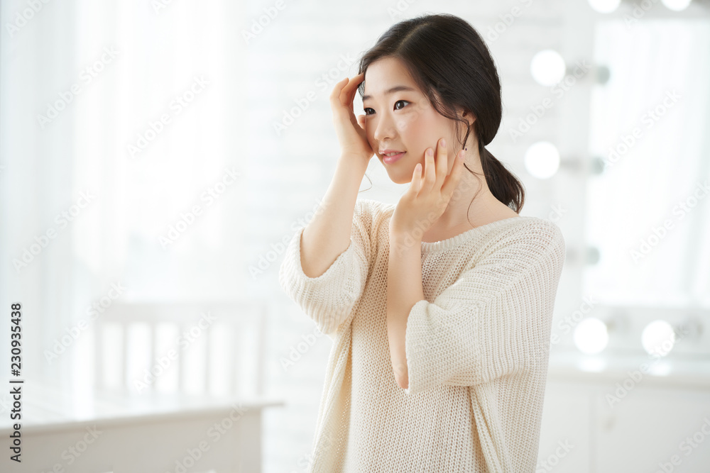 Smiling young Korean woman enjoying her beauty Smiling young Korean woman enjoying her beauty