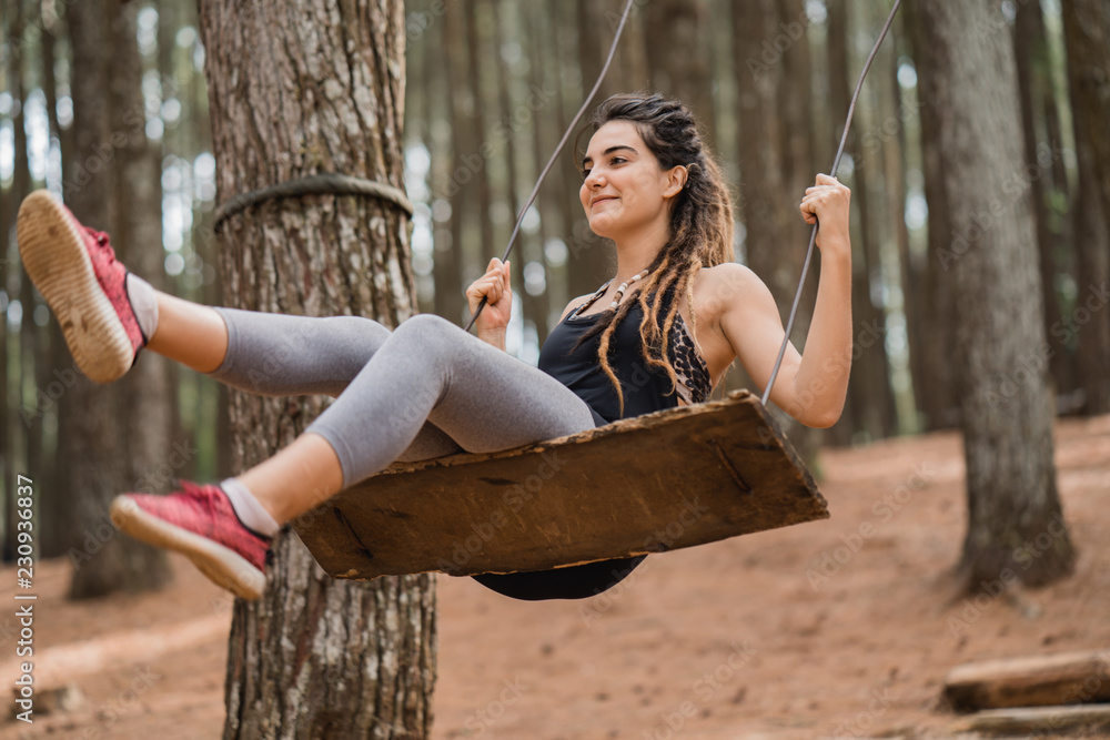 Naklejka premium Portrait of a happiness young woman playing on a swing