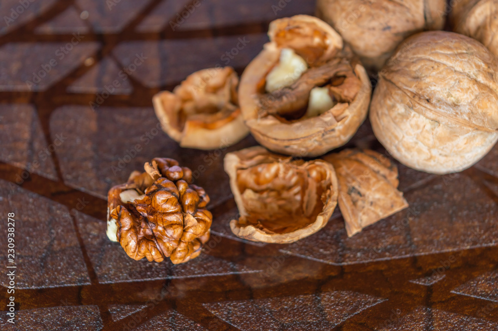 Some broken and unbrroken walnut shells on a table