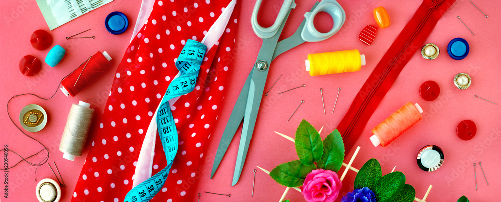 Items for sewing in the form of a panorama. Sewing clothes. Measuring tape, tailoring scissors, threads, buttons, needles, fabric on a pink background in the form of a panorama. - obrazy, fototapety, plakaty 
