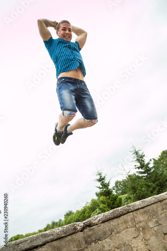 Portrait of handsome young man jumping against the sky