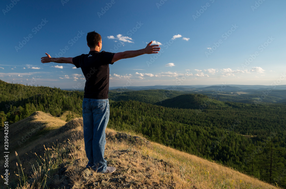 A man on a mountain looking into the distance. A man on a mountain looking into the distance.