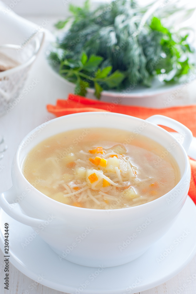 Chicken vermicelli soup and potatoes in a white bowl, selective focus Chicken vermicelli soup and potatoes in a white bowl, selective focus