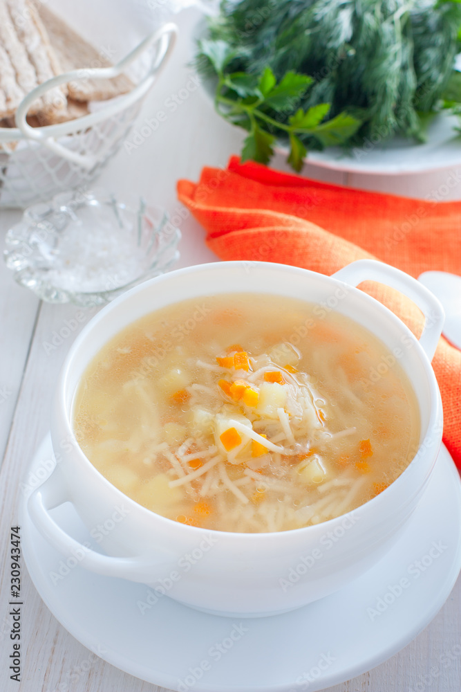 Chicken vermicelli soup and potatoes in a white bowl, selective focus Chicken vermicelli soup and potatoes in a white bowl, selective focus
