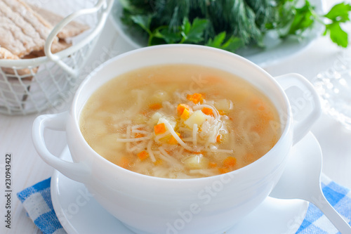 Chicken vermicelli soup and potatoes in a white bowl, horizontal