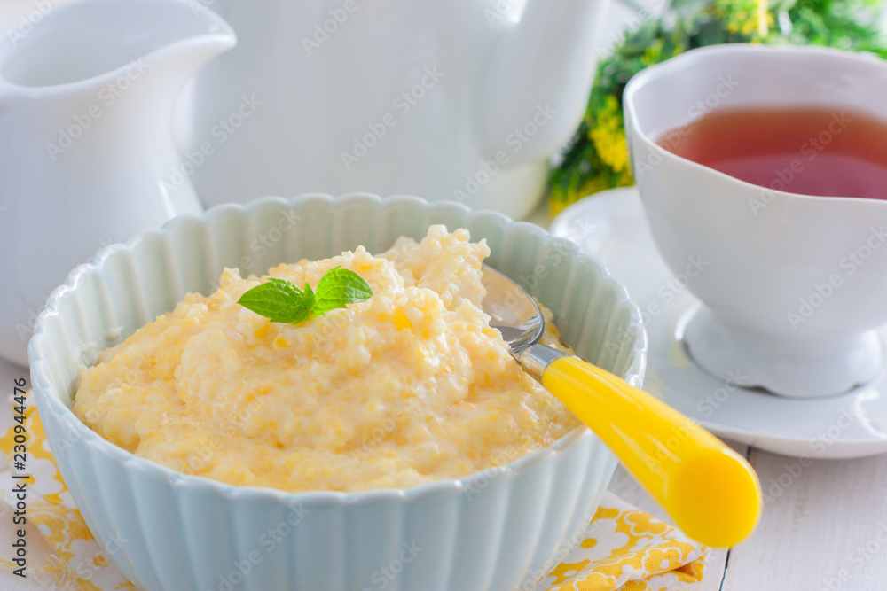 Milk corn porridge in a blue bowl, horizontal