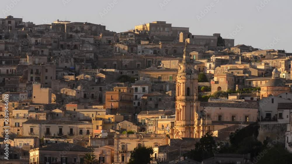 Modica in the Sicily - Italy with the landscape highlighted in church. Birds fly from side to side. Sunlight in some houses. Modica in the Sicily - Italy with the landscape highlighted in church. Birds fly from side to side. Sunlight in some houses.